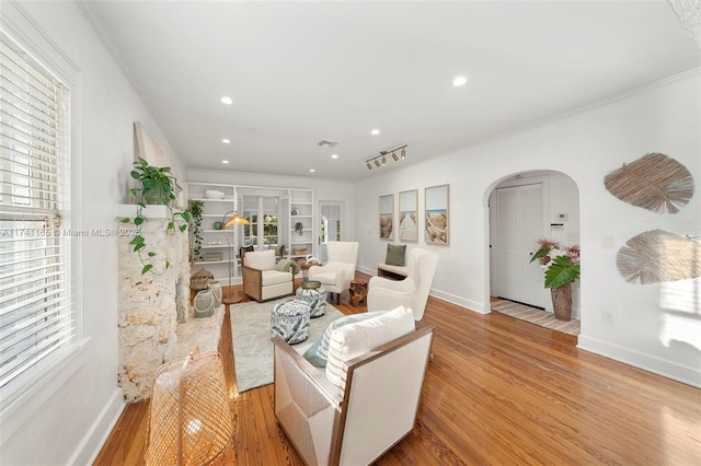 living room featuring ornamental molding and light hardwood / wood-style floors