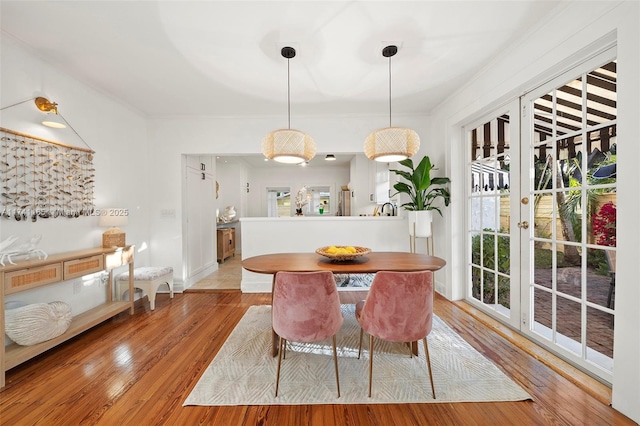 dining area with crown molding and light hardwood / wood-style floors