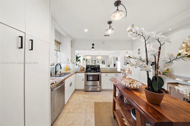 kitchen featuring appliances with stainless steel finishes, decorative light fixtures, sink, white cabinets, and light tile patterned floors