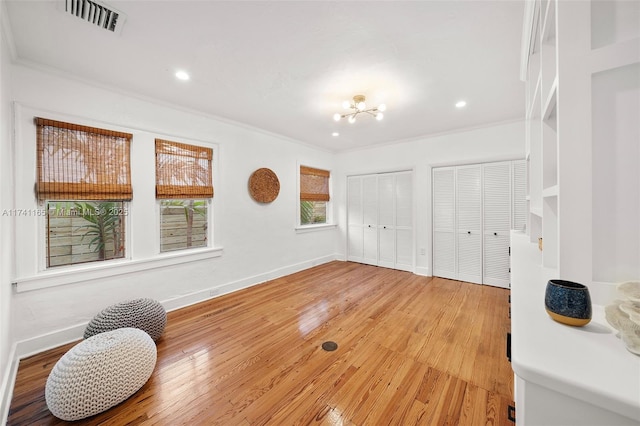 interior space featuring hardwood / wood-style floors, crown molding, and a notable chandelier