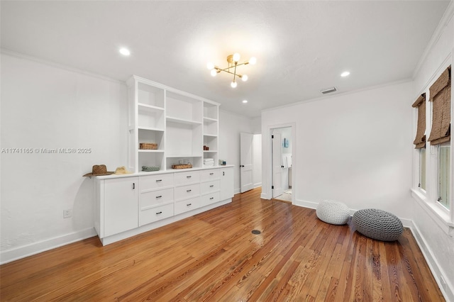 interior space featuring ornamental molding, hardwood / wood-style floors, and a chandelier