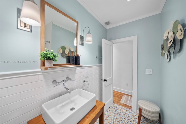 bathroom with vanity, wood-type flooring, ornamental molding, and tile walls