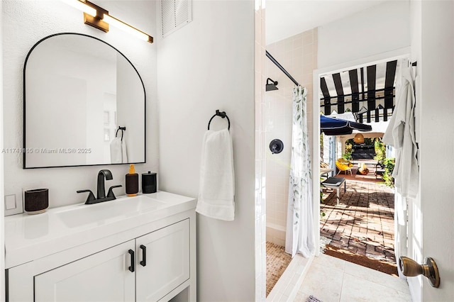 bathroom featuring tile patterned floors, vanity, and curtained shower