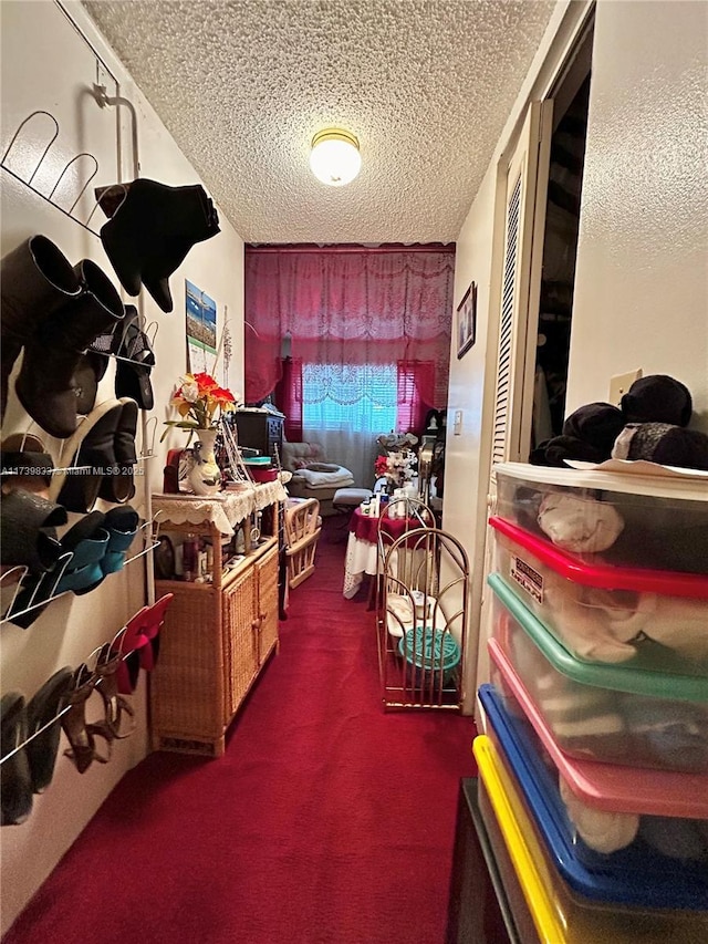 interior space with dark colored carpet and a textured ceiling