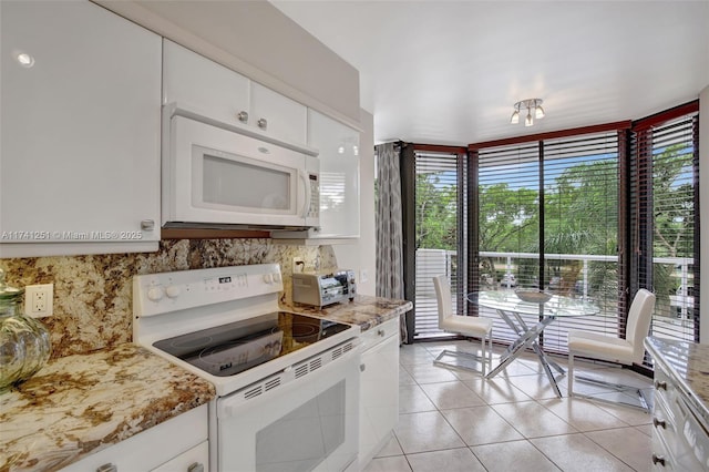 kitchen with white cabinetry, tasteful backsplash, light tile patterned floors, white appliances, and light stone countertops