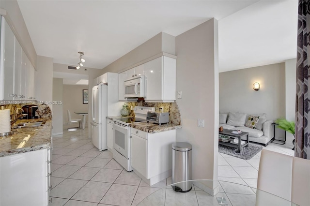 kitchen featuring light tile patterned floors, white appliances, tasteful backsplash, light stone counters, and white cabinets