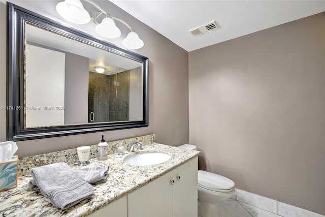 bathroom featuring vanity, a shower with shower door, tile patterned floors, and toilet