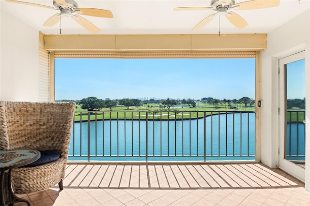 balcony with a water view and ceiling fan