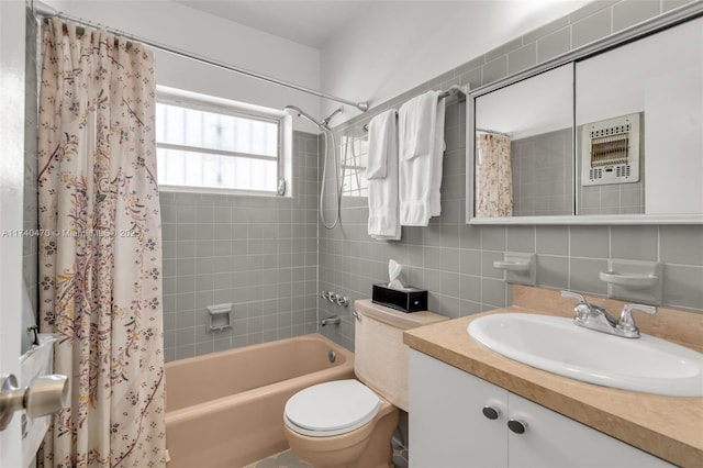 full bathroom featuring tasteful backsplash, tile walls, vanity, toilet, and shower / bath combo with shower curtain