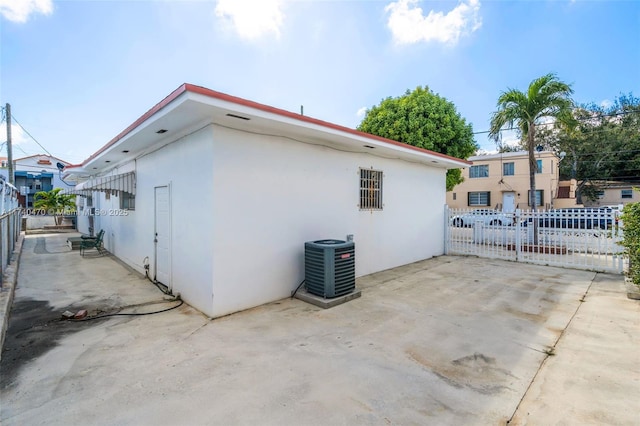 view of property exterior featuring central AC unit and a patio