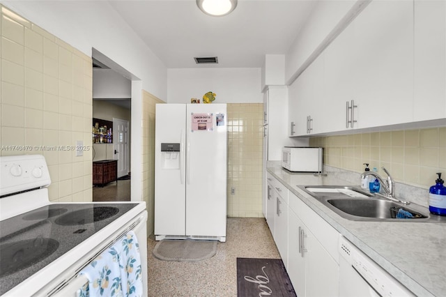 kitchen with white cabinetry, white appliances, sink, and tile walls