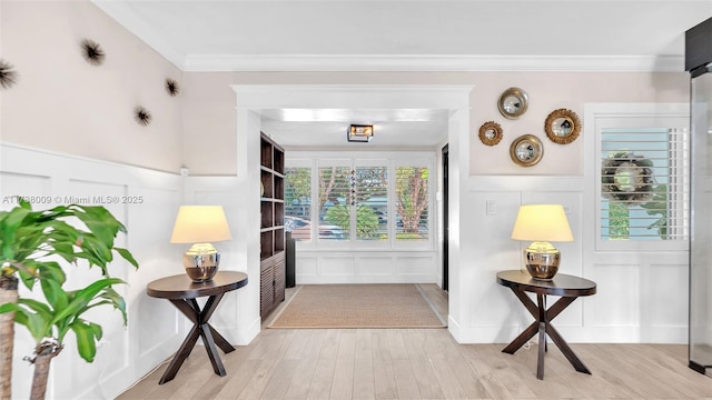 interior space featuring ornamental molding and light hardwood / wood-style floors