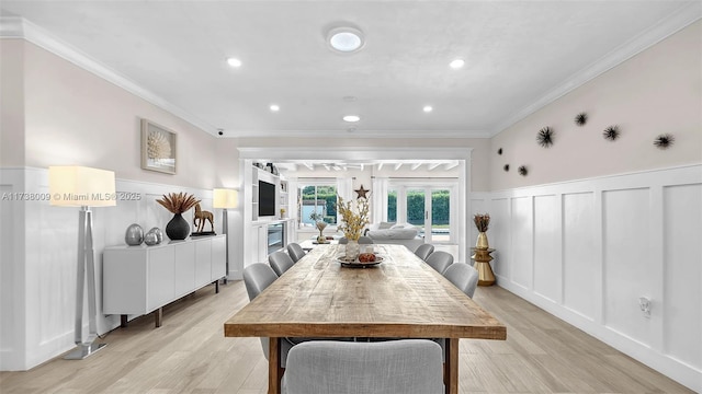 dining area with crown molding and light hardwood / wood-style floors