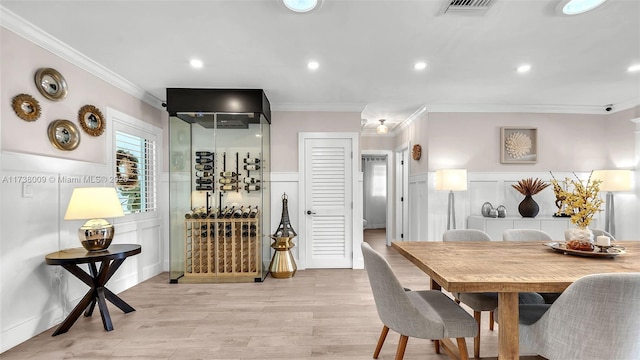 dining room with ornamental molding and light wood-type flooring