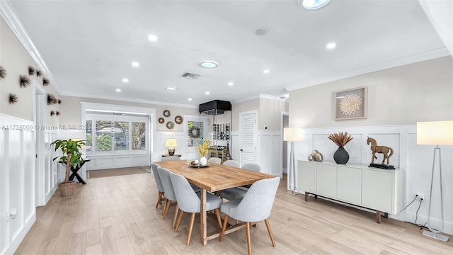 dining area featuring ornamental molding and light wood-type flooring