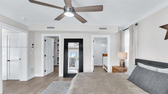 bedroom featuring wood-type flooring, a spacious closet, ensuite bathroom, and ceiling fan