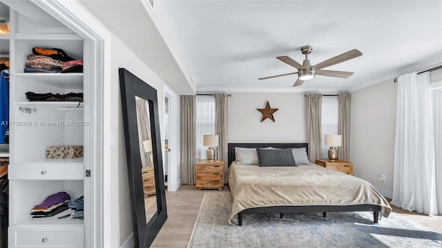 bedroom with crown molding, ceiling fan, and light hardwood / wood-style flooring