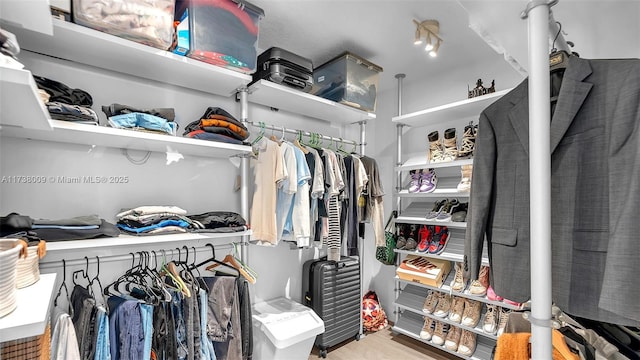 walk in closet with light hardwood / wood-style floors