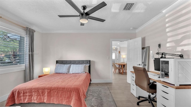 bedroom with crown molding, ceiling fan, a textured ceiling, and light hardwood / wood-style flooring