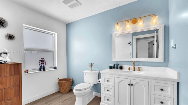 bathroom featuring wood-type flooring, a shower, vanity, and toilet