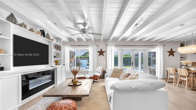 living room with beamed ceiling, ceiling fan, light hardwood / wood-style flooring, and french doors