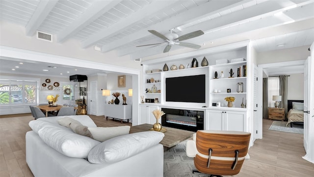 living room with beamed ceiling, ceiling fan, and light wood-type flooring