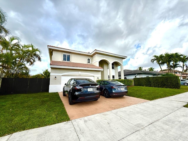 mediterranean / spanish home with a garage, decorative driveway, a front yard, and stucco siding