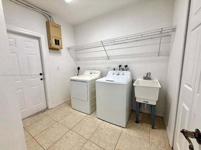 laundry room featuring light tile patterned floors, laundry area, a sink, independent washer and dryer, and electric panel