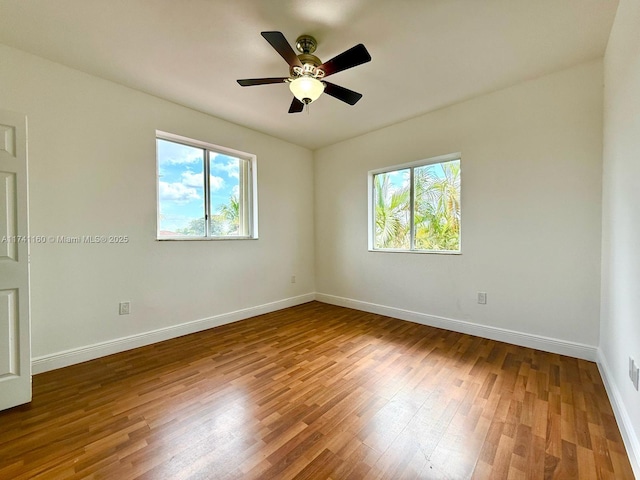 spare room with ceiling fan, baseboards, and wood finished floors