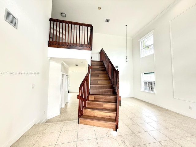 stairway featuring visible vents, crown molding, and tile patterned floors