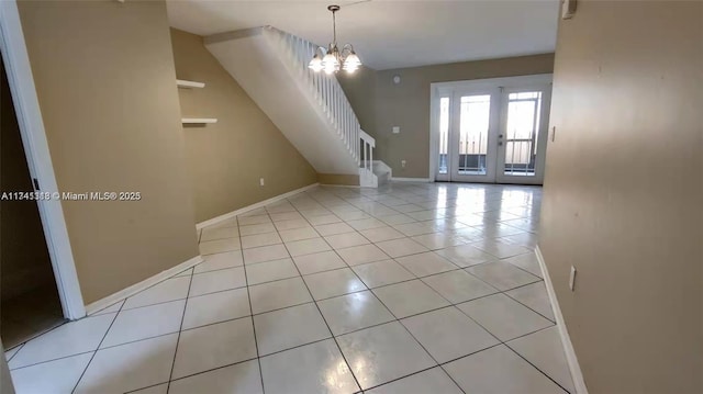 interior space with light tile patterned floors, french doors, and a chandelier