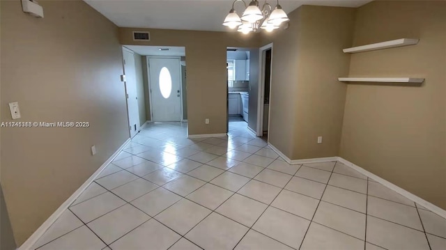 tiled entryway featuring a notable chandelier