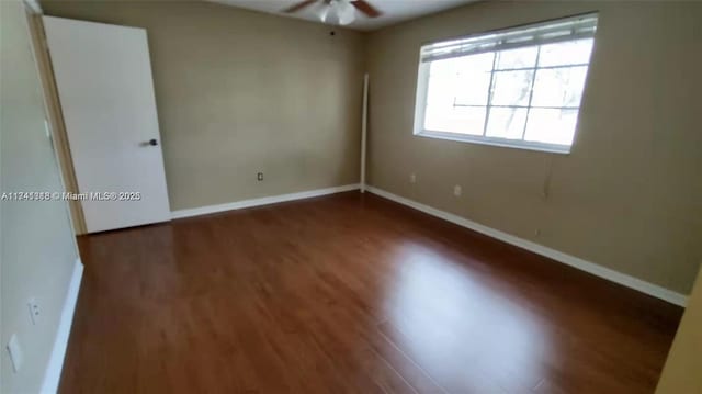 unfurnished room with ceiling fan and dark hardwood / wood-style flooring