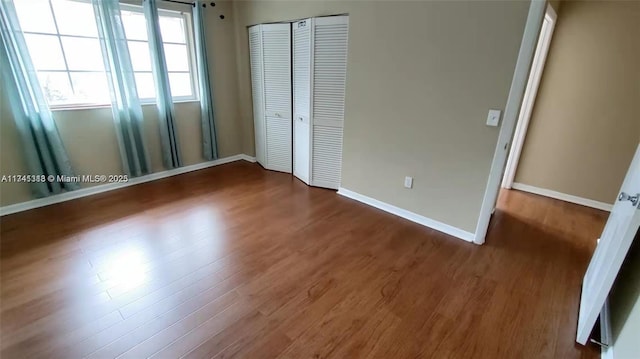 unfurnished bedroom featuring dark wood-type flooring and a closet