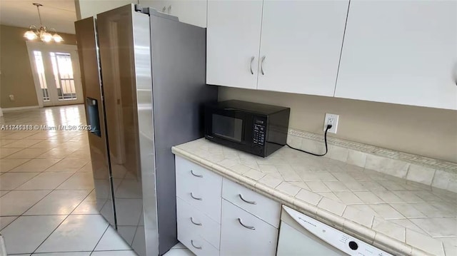 kitchen with hanging light fixtures, dishwasher, light tile patterned floors, and white cabinets