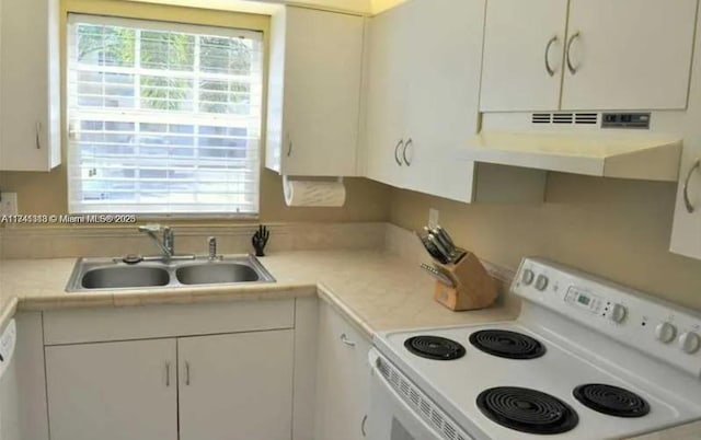 kitchen with a healthy amount of sunlight, sink, white cabinets, and white range with electric stovetop