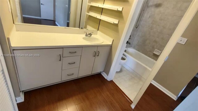 full bathroom featuring hardwood / wood-style flooring, vanity, shower / bath combination, and toilet