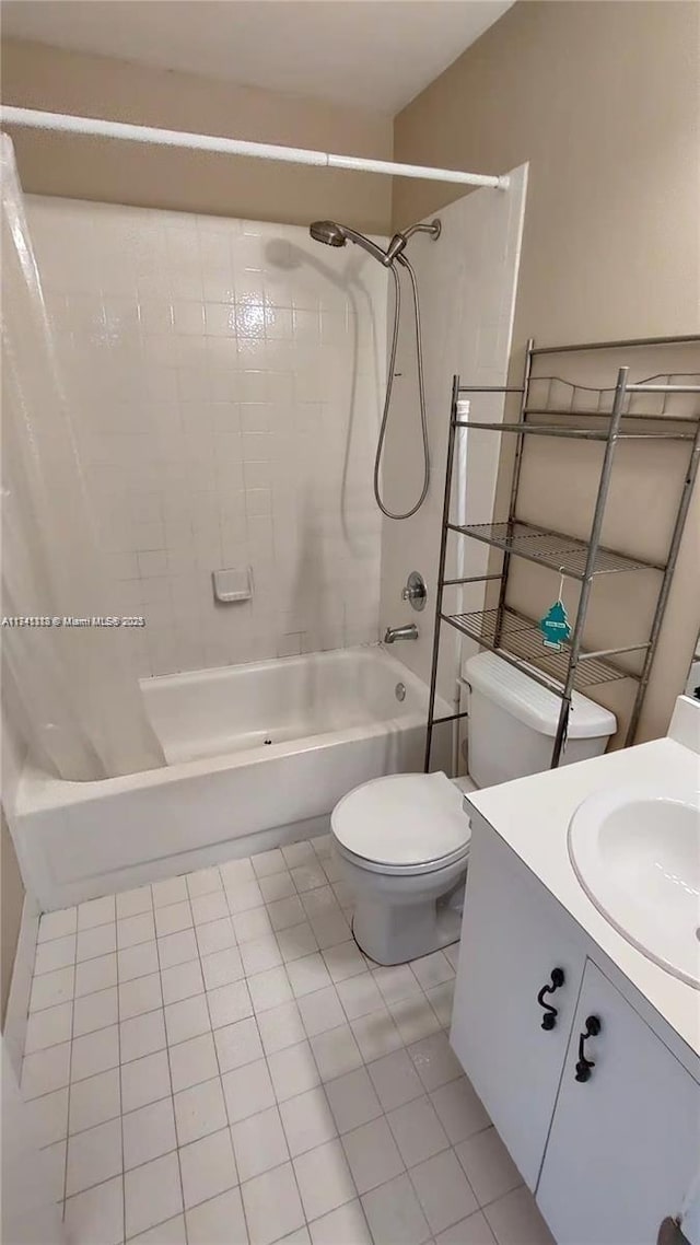 full bathroom featuring vanity, tiled shower / bath, tile patterned floors, and toilet