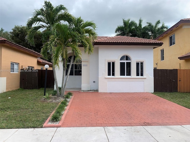 mediterranean / spanish-style home featuring a patio and a front lawn