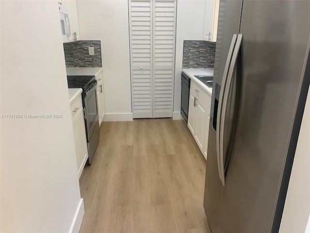 2511 NE 41st Ter, Homestead, FL 33033 - kitchen with stainless steel appliances, white cabinetry, decorative backsplash, and light hardwood / wood-style flooring