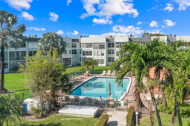 view of swimming pool featuring a patio and a yard