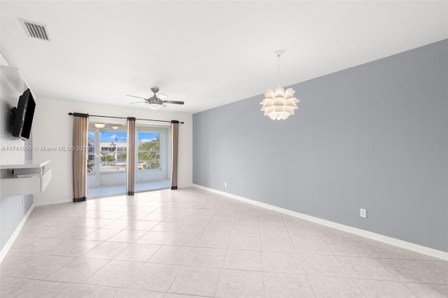 tiled spare room with ceiling fan with notable chandelier