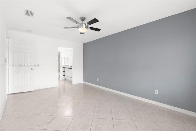 tiled spare room featuring ceiling fan