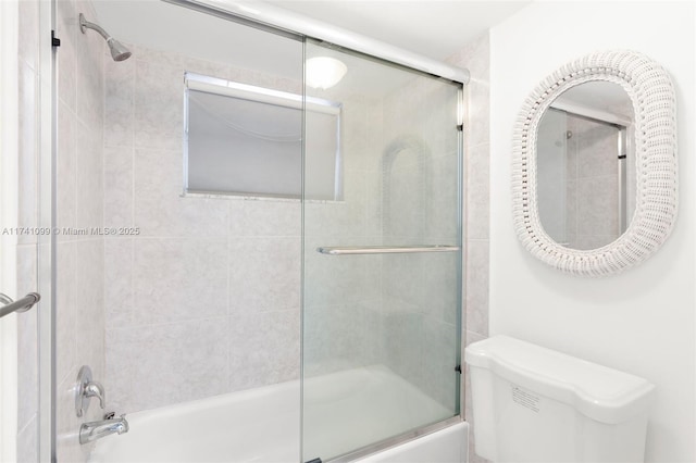 bathroom featuring shower / bath combination with glass door and toilet