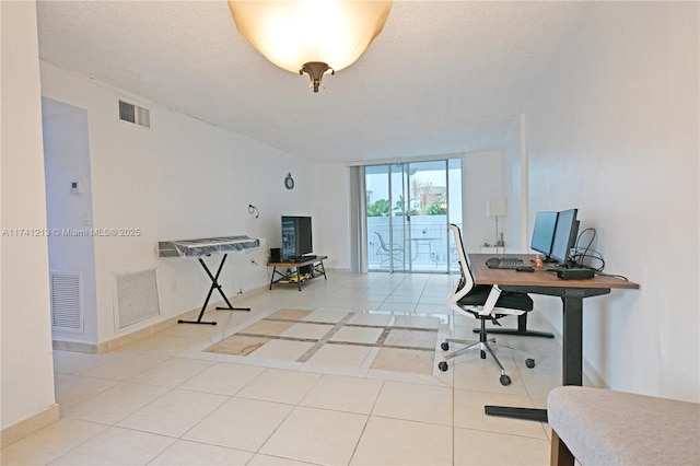 tiled office space with a textured ceiling