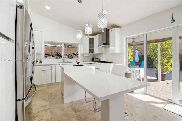 kitchen featuring sink, white cabinetry, stainless steel appliances, a center island, and wall chimney exhaust hood