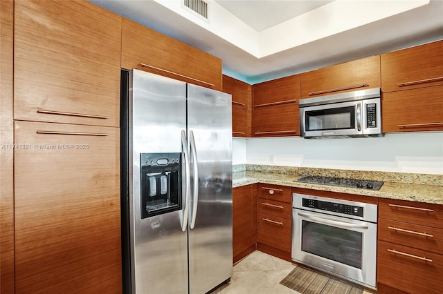 2681 N Flamingo Rd Unit 605S, Sunrise, FL 33323 - kitchen featuring stainless steel appliances, brown cabinetry, light stone countertops, and light tile patterned floors
