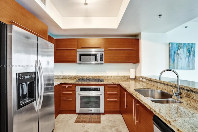 2681 N Flamingo Rd Unit 605S, Sunrise, FL 33323 - kitchen with appliances with stainless steel finishes, a sink, brown cabinets, light stone countertops, and a tray ceiling