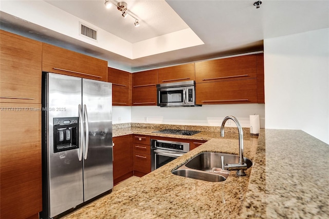 2681 N Flamingo Rd Unit 605S, Sunrise, FL 33323 - kitchen featuring stainless steel appliances, a sink, light stone countertops, brown cabinets, and a raised ceiling