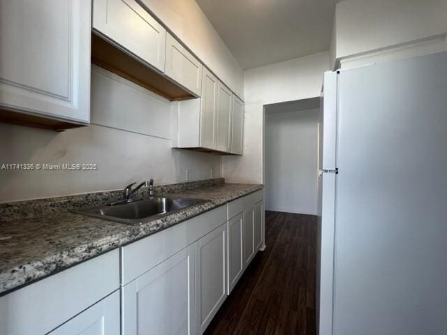 kitchen featuring sink, white cabinets, and white refrigerator